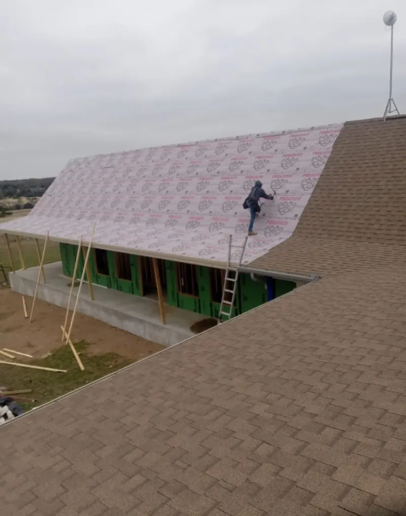 Worker preparing underlayment for a metal roof installation in Bardstown